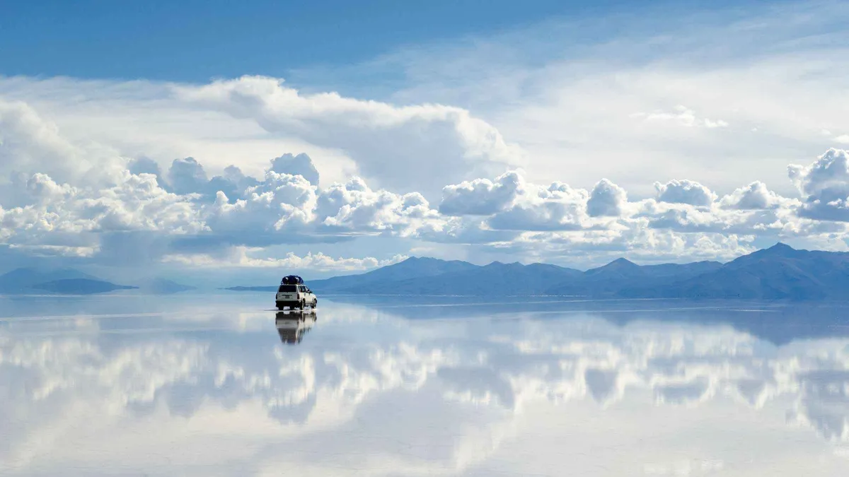 A 4x4 jeep parked among salt blocks at the original Salt Hotel on a Uyuni salt flats tour